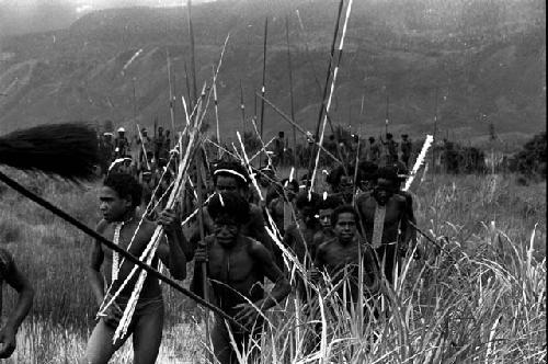 Group of warriors running past the cameraman, back from the battle front