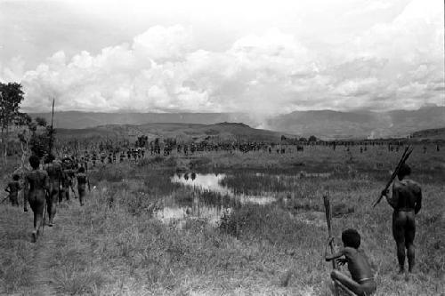 Long line of warriors going past the pond on the wat to a war on the Tokolik