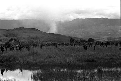 Long line of warriors going past the pond on the wat to a war on the Tokolik