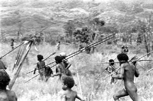 A group of men running to the front, weapons in hand