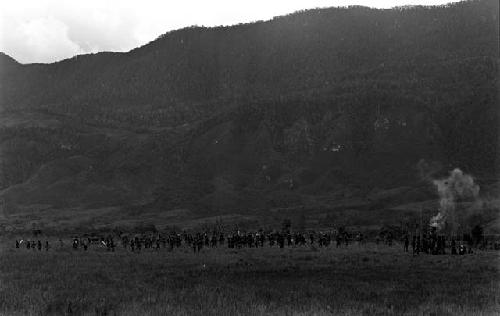 A large group of warriors waiting near the end of the Tokolik; smoke off to the right