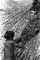 Men thatching the roof of a building under construction in the new village of Kumina