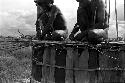 Two men working on the sleeping platform of a honai under construction