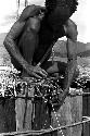 A man working on the sleeping platform of a honai under construction