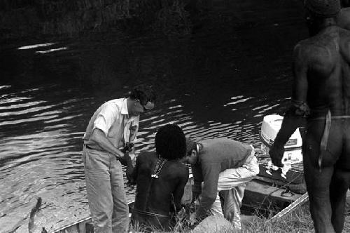 Weaklekek helps Peter Matthiessen and Robert Gardner take things from their boat