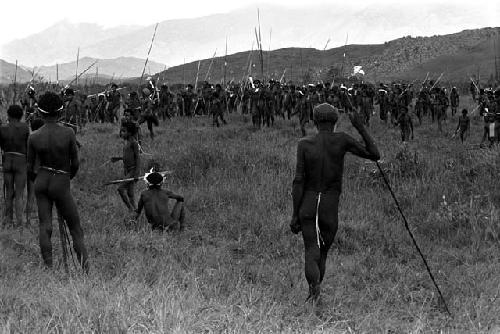 Very large group of warriors waiting on the Tokolik, many spears among them; hills beyond