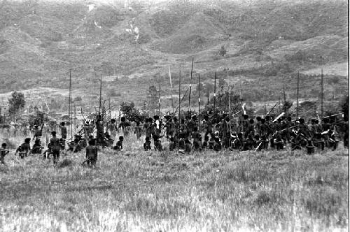 A large group of Willihiman-Wallalua warriors wait for the battle to resume; hills beyond