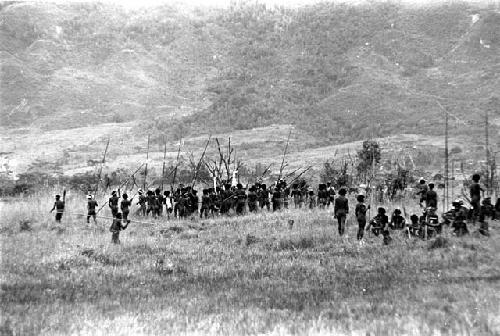 A large group of Willihiman-Wallalua warriors wait for the battle to resume; hills beyond