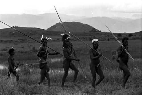 Men coming back from the battle front with their weapons, along the pond on the Tokolik