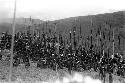 Large group of men seated with spears all around