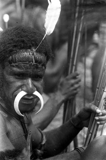 Yegé Asuk with a bone ornament in his nose and a feather in his hair