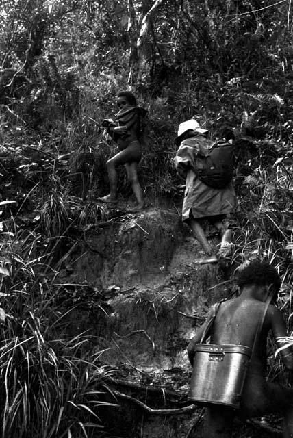 Young boys carrying expedition equipment on the path to Lokoparek