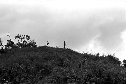 Figures standing on the hill behind Abukulmo