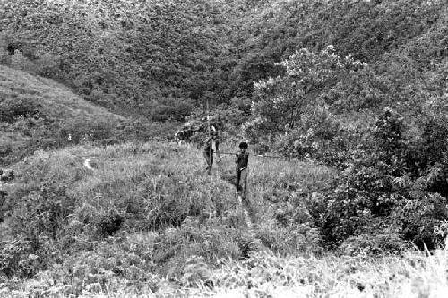 Figures standing on the hill behind Abukulmo