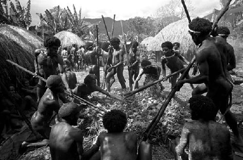 Men lifting stones from a fire, to be put into the haksé
