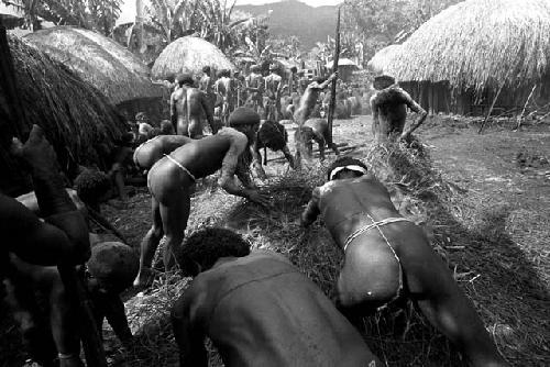 Men covering the top of the haksé with hay