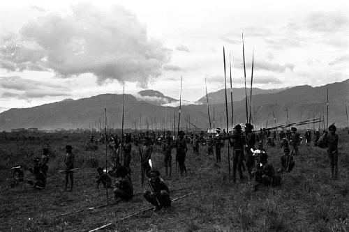 Men wait with long spears at the rear of a battle