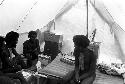 Aloro, Husuk, Loliluk, and Walimo sitting in Robert Gardner's expedition tent