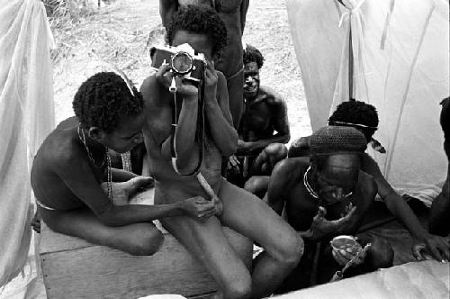 Men playing with a camera in Robert Gardner's expedition tent