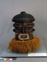 Ceremonial wood mask with raffia fringe