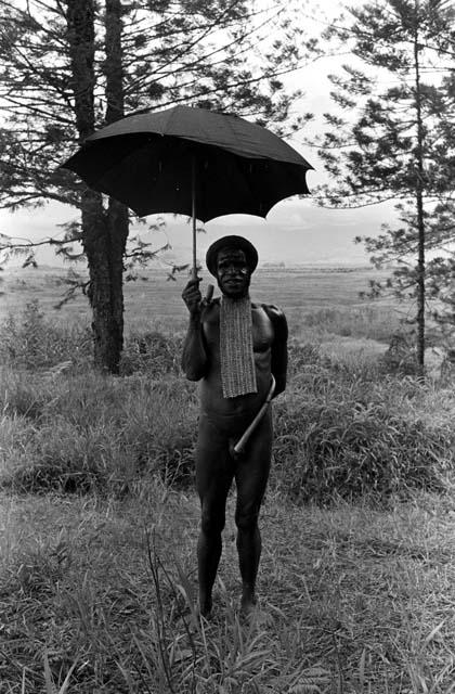 A man standing under an umbrella