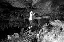 A man holds a torch to light his descent into the bat cave