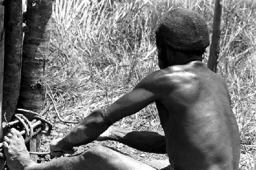 man tightening vines at the base of the kaio