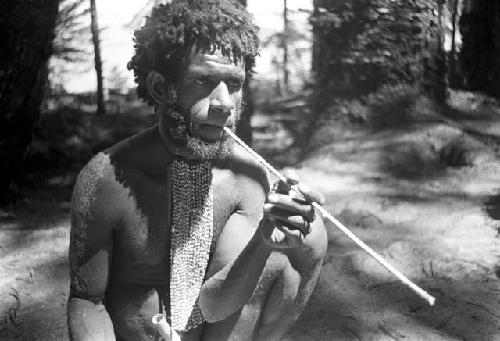 Husuk smokes a cigarette in a long reed holder