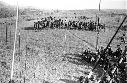 dead birds; spears against the olea; and people dancing in the background