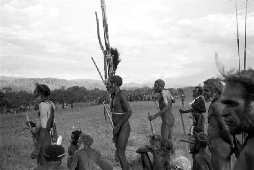 dead birds; spears against the olea; and people dancing in the background