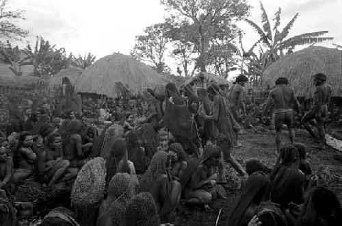 Men begin to build the funeral pyre; mourners all around