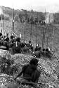 Men sitting on the Warabara, spears in hand -- blurry negative