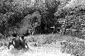 Boys sit by a place where wood is gathered, near Lokoparek