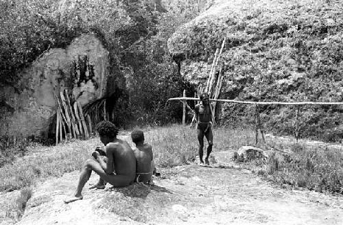 Boys sit by a place where wood is gathered, near Lokoparek