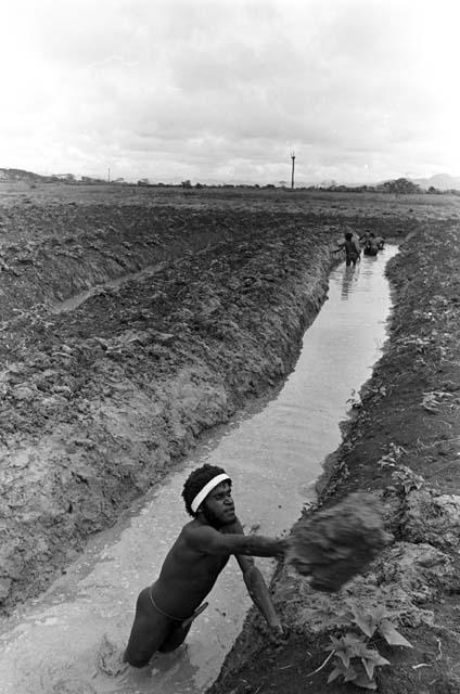 Men working on a garden ditch