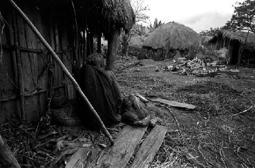 A solitary woman watches the funeral pyre at Kibit Silimo