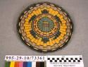 Plaited wicker circular plaque with turtle motif