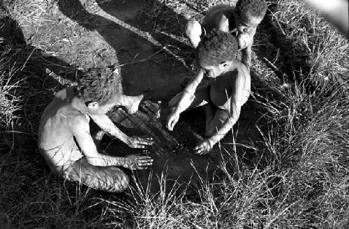 Small children playing a war game with munika seeds