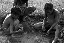 Small children playing a war game with munika seeds