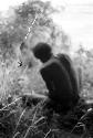 Spider and web in the foreground, man works on something in the background