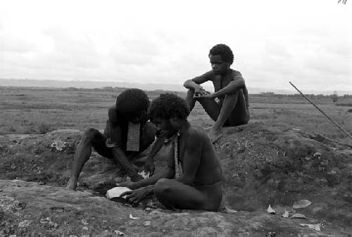 Men working on a mikak (shell neck band)