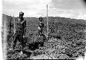 A man works in his garden as his daughter watches