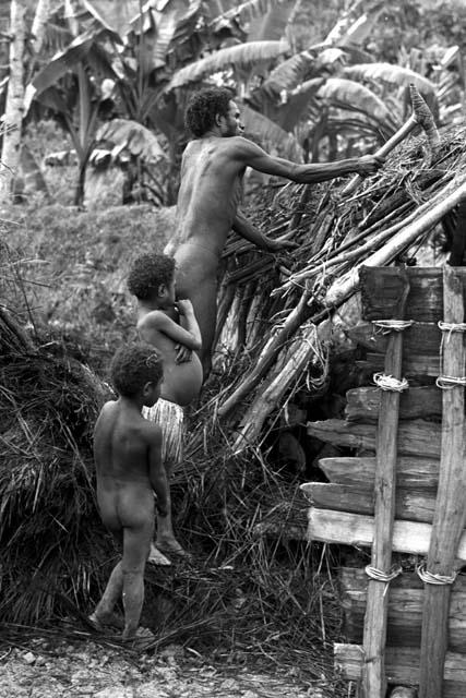 Children watch as a man tears apart an old hunu in Abukulmo