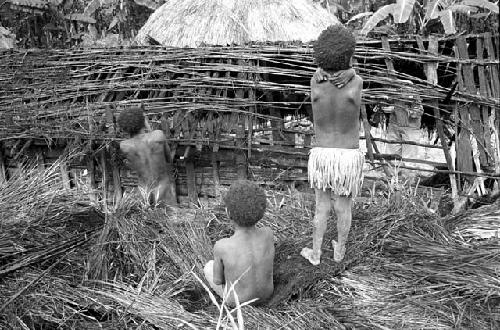 Children watch as a man tears apart an old hunu in Abukulmo