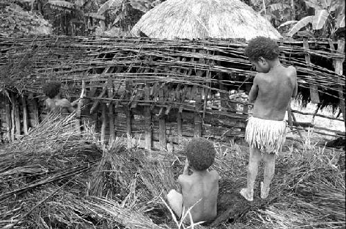 Children watch as a man tears apart an old hunu in Abukulmo