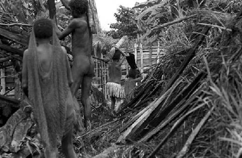 Children carrying wood away that will be used again