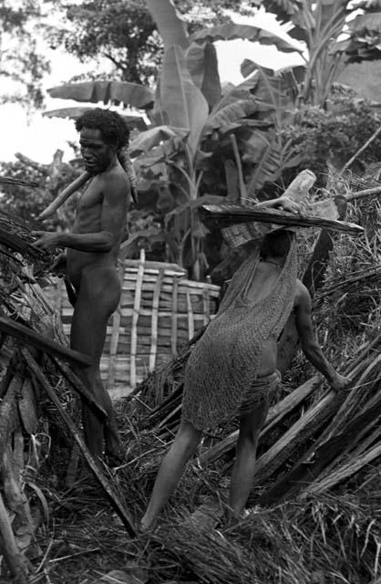 Asikanilek works at retrieving lumber from the old hunu