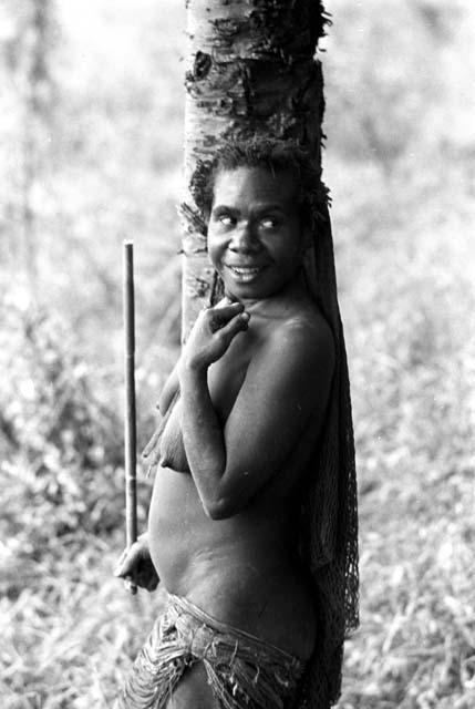 Woman standing by a sien tree