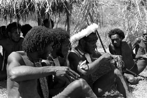 Men sitting under an oléa looking out; Weaklekek; Tegé Warek and Yege Asuk