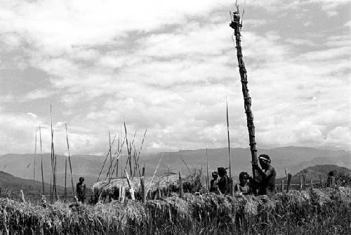 A man sitting up in the Hellerabet kaio, warriors and spears below